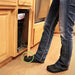person's legs opening cabinet door with foot. Device used is a clear ToeIn cabinet door foot pull.